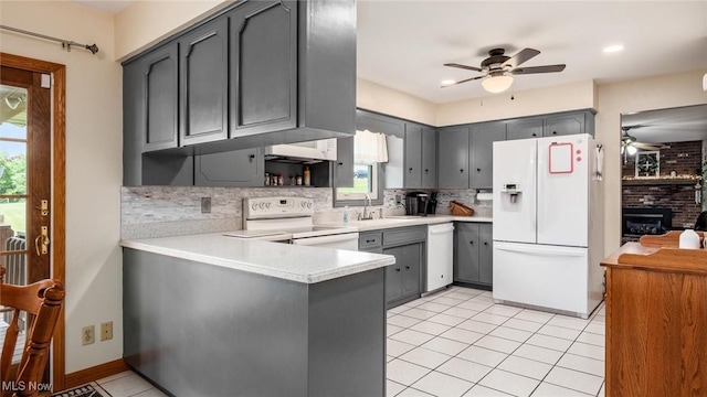 kitchen featuring white appliances, backsplash, and gray cabinetry