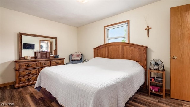 bedroom with dark wood-style floors and baseboards