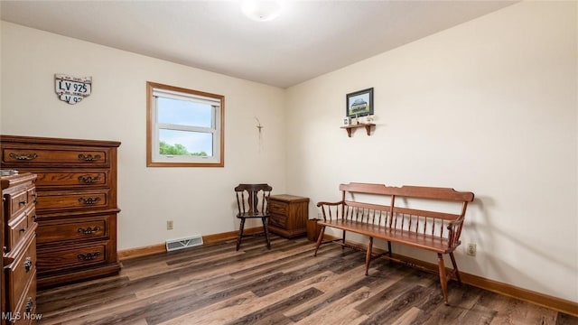 living area featuring visible vents, baseboards, and dark wood-style flooring