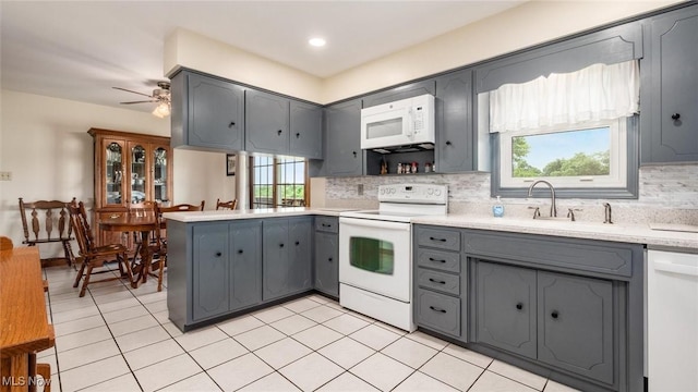 kitchen with gray cabinets, white appliances, a peninsula, light countertops, and decorative backsplash