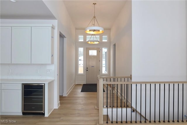 foyer with light hardwood / wood-style floors and beverage cooler