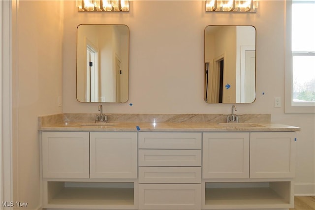 full bathroom with double vanity and a sink