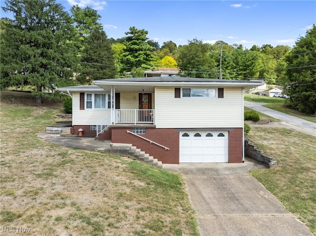 view of front of house featuring a porch, a front yard, and a garage