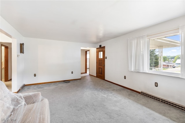 empty room featuring light carpet and baseboard heating