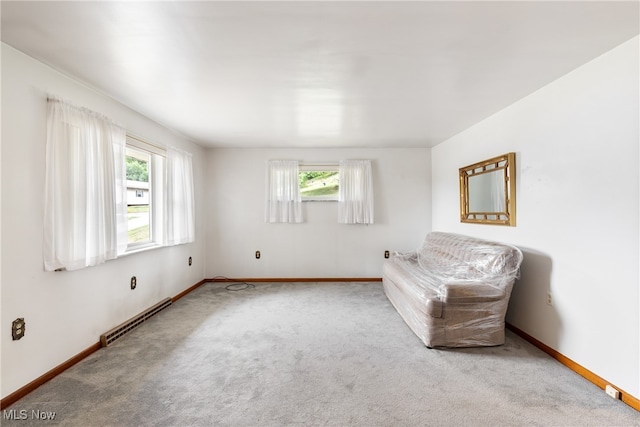 living area featuring carpet flooring and a baseboard heating unit