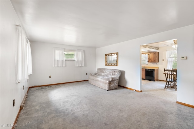 unfurnished living room featuring ceiling fan and light carpet