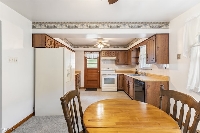 kitchen featuring ceiling fan, light carpet, tasteful backsplash, sink, and white appliances