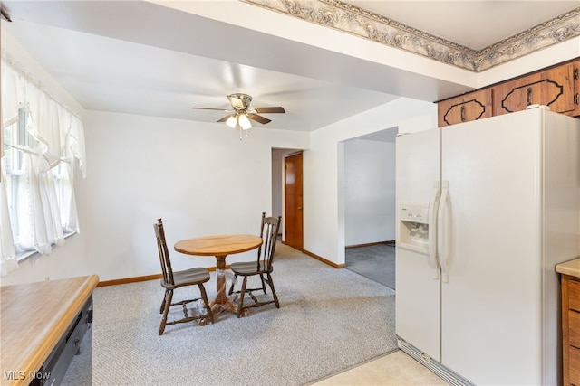 dining area featuring ceiling fan and light colored carpet