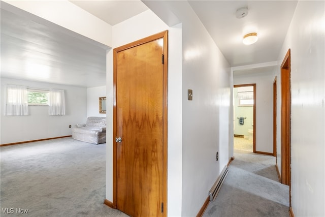 hallway featuring a baseboard heating unit and light carpet