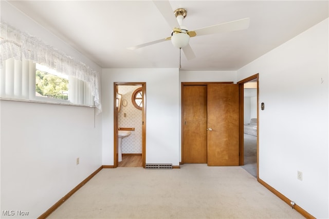 unfurnished bedroom featuring carpet floors, connected bathroom, a closet, and ceiling fan