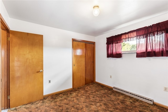 unfurnished bedroom featuring carpet flooring, a baseboard radiator, and a closet