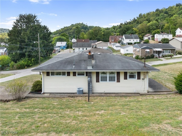 rear view of property with a yard and cooling unit