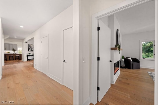 hall with recessed lighting and light wood-style flooring