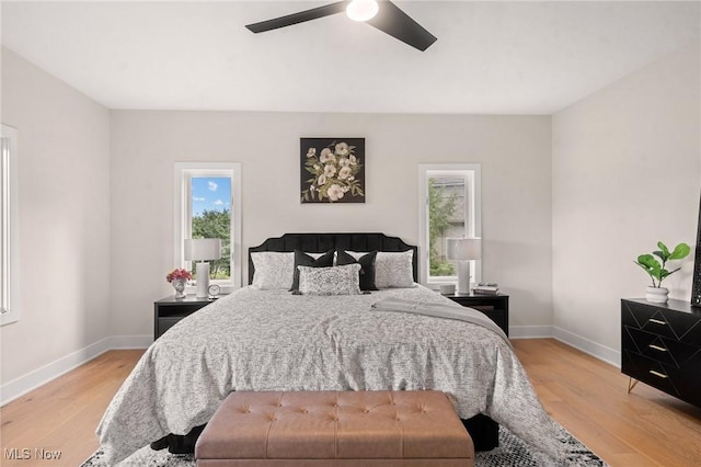 bedroom featuring baseboards, light wood-style flooring, and a ceiling fan