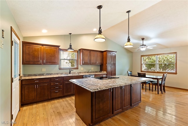 kitchen featuring sink, a center island, lofted ceiling, and light wood-type flooring