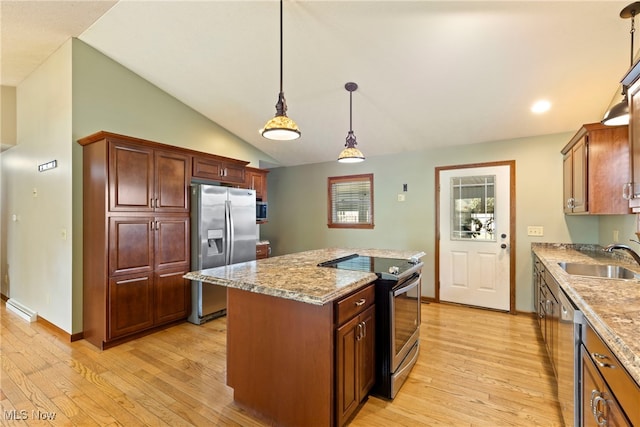 kitchen with a kitchen island, hanging light fixtures, appliances with stainless steel finishes, light hardwood / wood-style floors, and sink