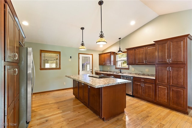 kitchen featuring light wood-type flooring, hanging light fixtures, appliances with stainless steel finishes, a center island, and lofted ceiling