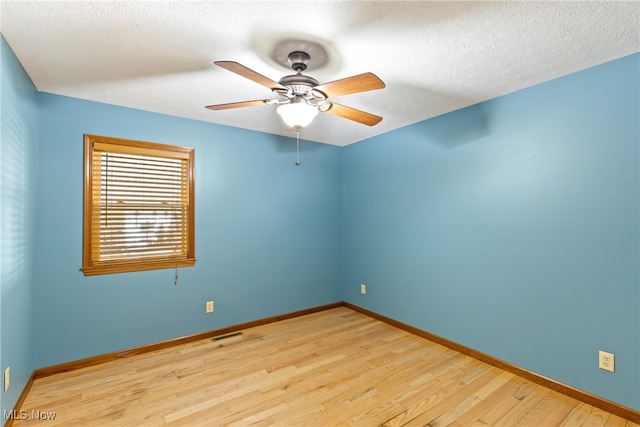 unfurnished room with a textured ceiling, light hardwood / wood-style flooring, and ceiling fan