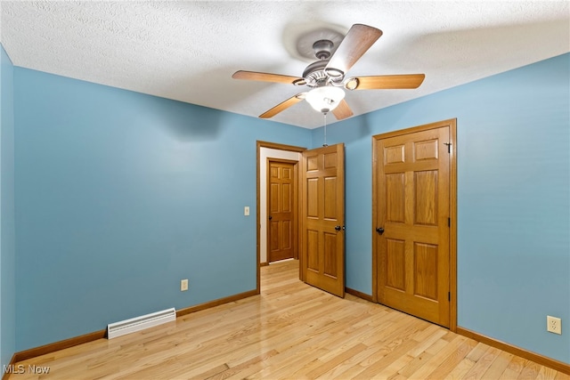 interior space featuring ceiling fan, light hardwood / wood-style flooring, and a textured ceiling