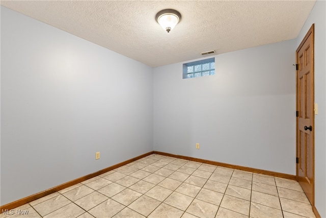 unfurnished room with light tile patterned floors and a textured ceiling