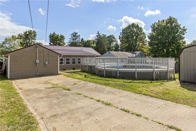 exterior space with a storage unit, a wooden deck, and a front yard