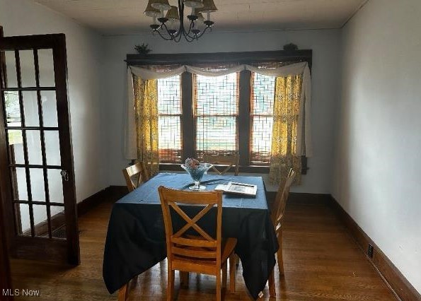 dining area with hardwood / wood-style flooring and a notable chandelier