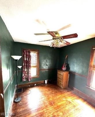 unfurnished room with ceiling fan and hardwood / wood-style floors