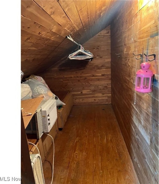 interior space with lofted ceiling, wood ceiling, hardwood / wood-style flooring, and wooden walls