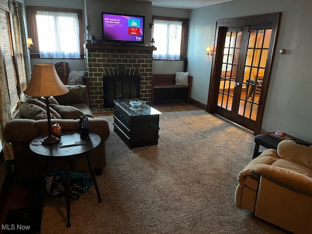 living room featuring a healthy amount of sunlight, carpet, and a brick fireplace