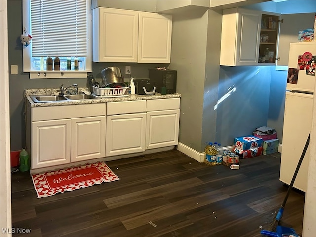 kitchen with sink, dark wood-type flooring, white cabinets, and white fridge