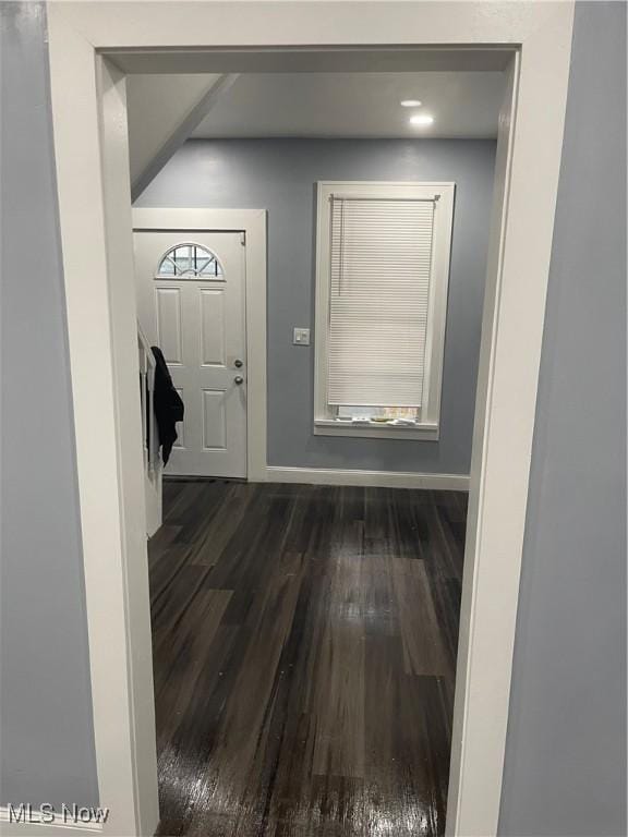 entrance foyer featuring baseboards and dark wood finished floors