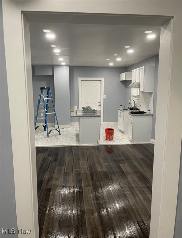 kitchen featuring white cabinets, sink, and hardwood / wood-style floors