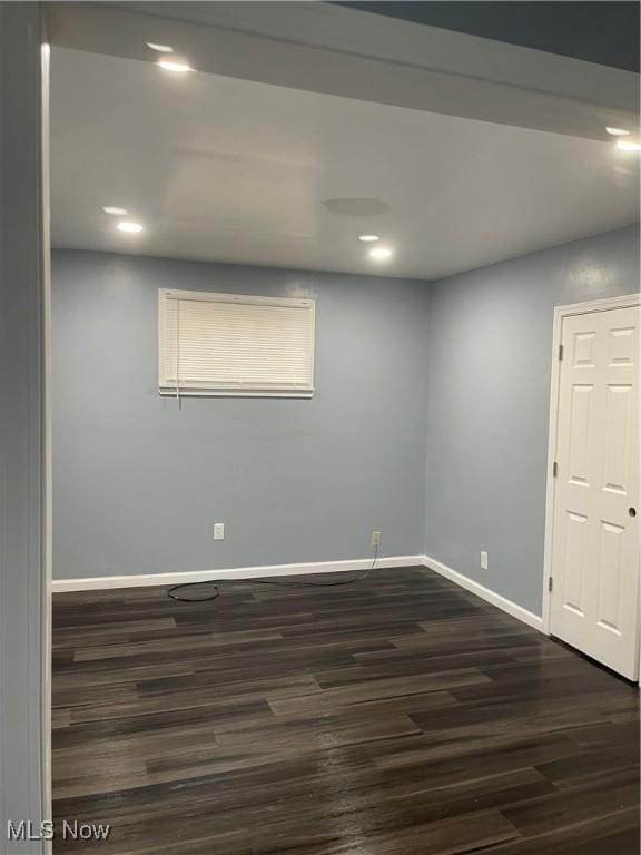 empty room featuring recessed lighting, dark wood-style floors, and baseboards