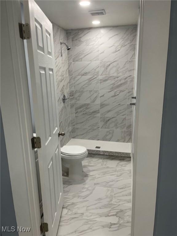 bathroom featuring visible vents, marble finish floor, a stall shower, and toilet
