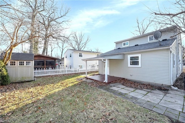 back of house featuring an outbuilding, a patio area, and a yard