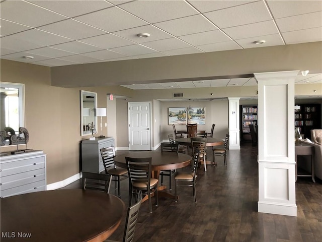 dining room featuring decorative columns, visible vents, a paneled ceiling, baseboards, and dark wood-type flooring