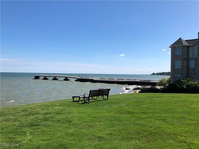 view of property's community featuring a lawn and a water view