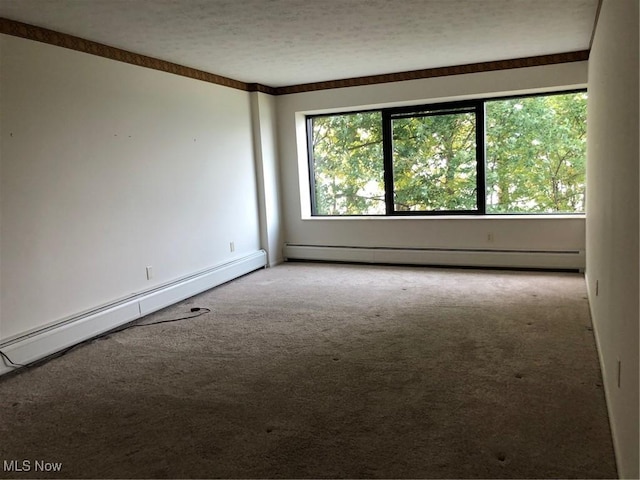 carpeted spare room with a baseboard radiator and a textured ceiling