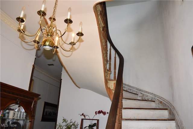 staircase with a chandelier