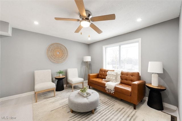 living room with ceiling fan and light hardwood / wood-style flooring