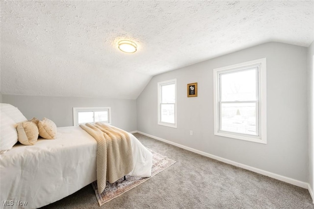 bedroom featuring carpet flooring, a textured ceiling, and lofted ceiling