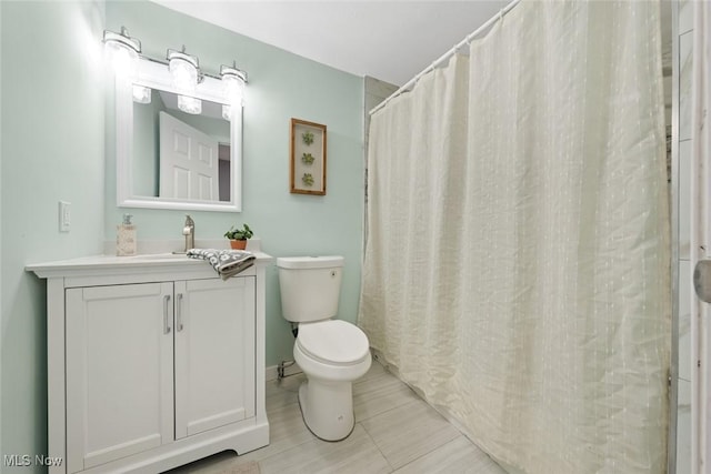 bathroom with vanity, toilet, and walk in shower