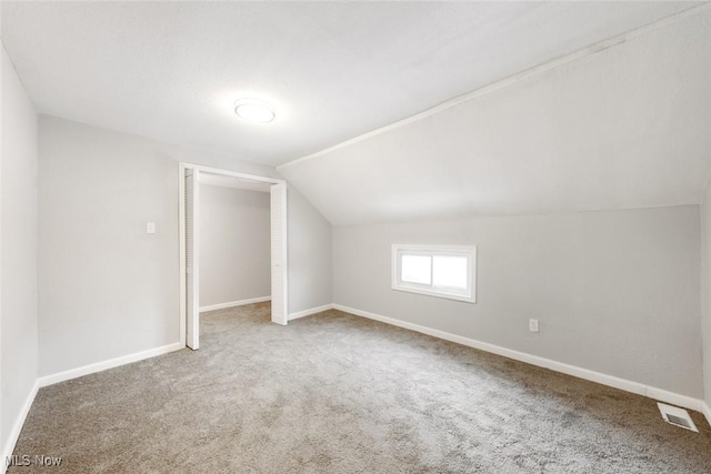 bonus room with carpet flooring and vaulted ceiling