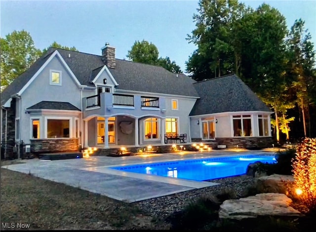 back of house featuring a balcony and a patio