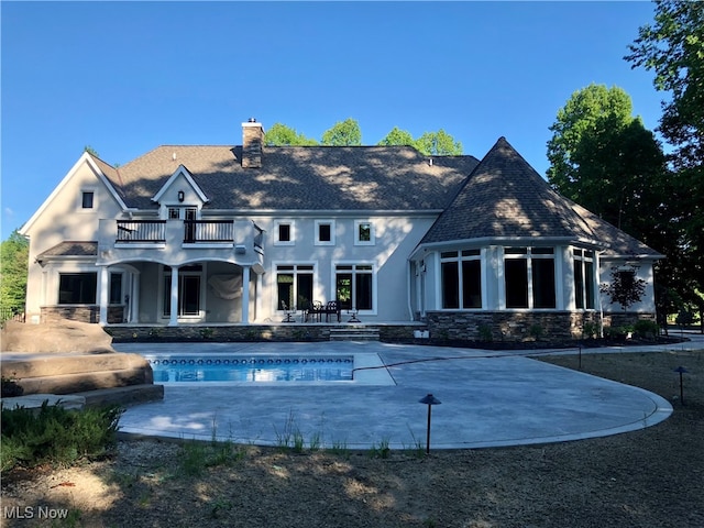 back of property with a balcony and a patio area