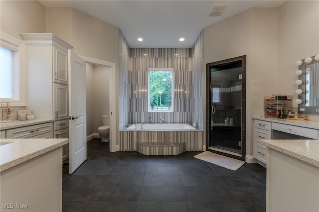 full bathroom with shower with separate bathtub, vanity, toilet, and tile patterned floors