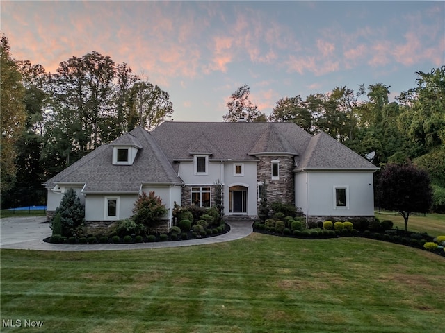 french country inspired facade featuring a lawn