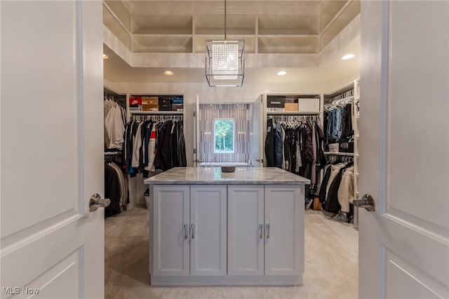 spacious closet featuring light colored carpet and a raised ceiling