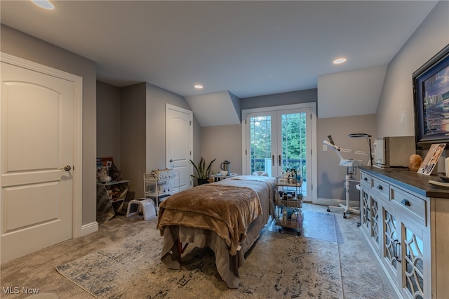 bedroom with vaulted ceiling, light colored carpet, access to exterior, and french doors