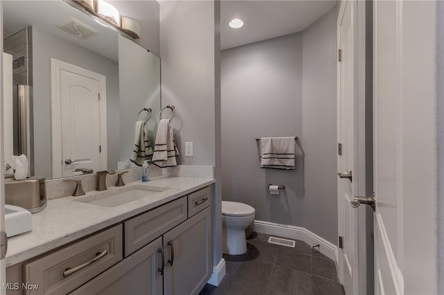 bathroom featuring tile patterned flooring, vanity, and toilet